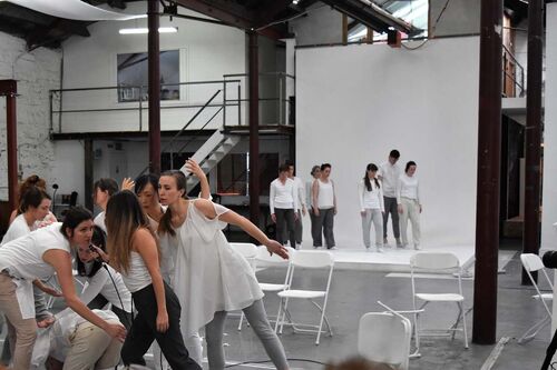 A group of participants in movement with another group still in the background