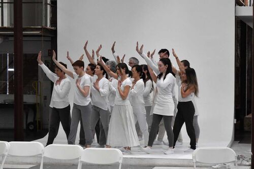 An ensemble of participants all in white dancing