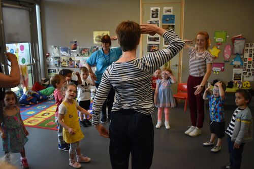 Philippa Donnellan and Olwyn Lyons in a circle with a group of children