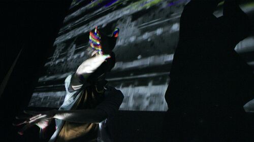 David Bolger in shadow with projections cast over him