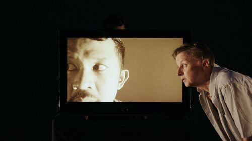 Donking Rongavilla's face on screen and David Bolger on stage