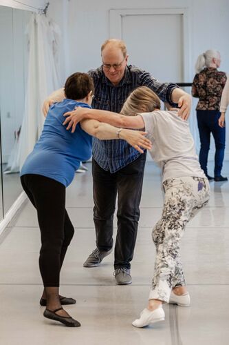 Three participants connected in movement in a studio