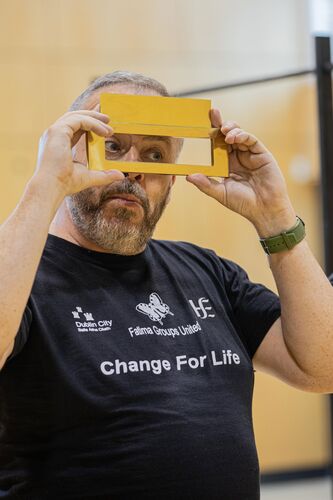 A participant looking through a letterbox held to their face