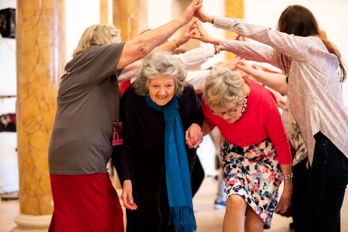 Participants ducking under an arch of others' arms