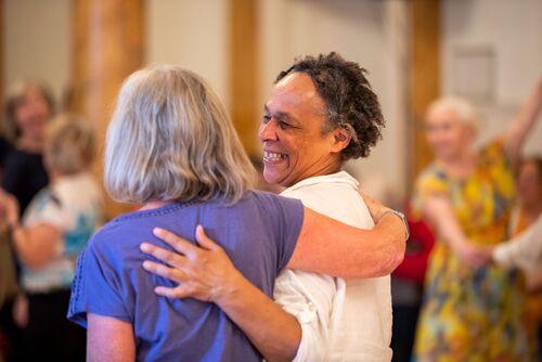 Two participants with their arms around each other, laughing