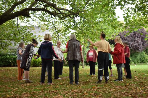 A circle of figures in an open park space