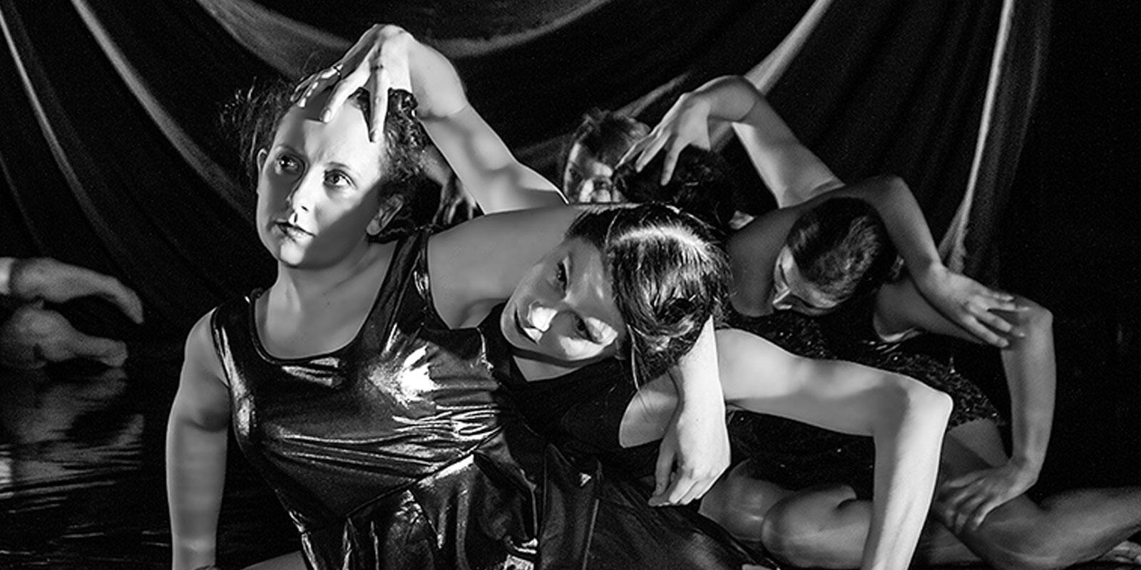 Two figures on the floor with limbs entwined