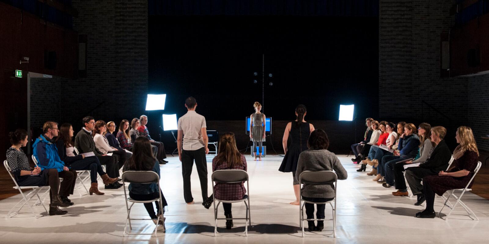People seating on chairs and watching the performer