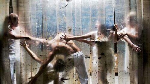 Five figures pressed against a heavy curtain of plastic