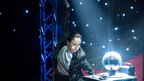 A figure looking into a disco ball that has light shining down on it