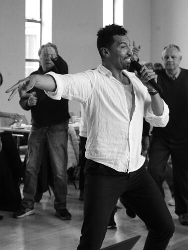 A dancer in a movement speaking into a microphone