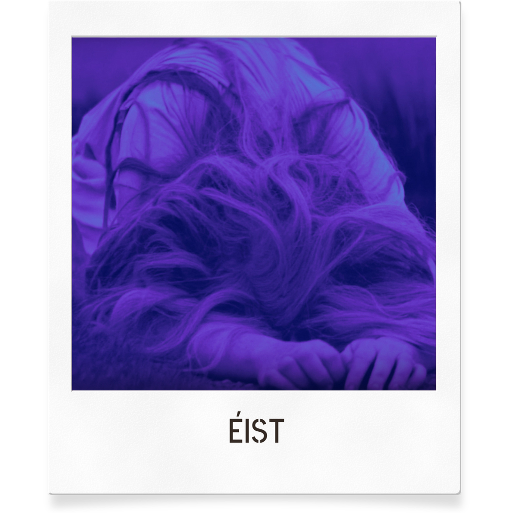 A blue filtered image of a woman lying face down on the ground with her hands and hiding her face