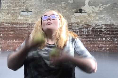 A woman juggling two balls