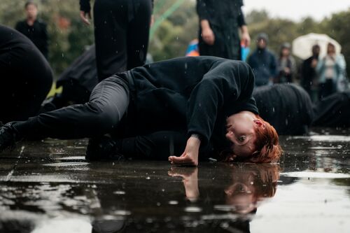 A woman lying on the ground in a puddle