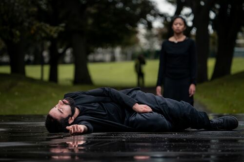 A man lying on the ground in a puddle