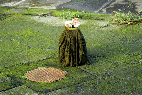 A dancer hidden in a skirt with her hands coming out of it