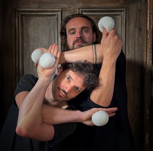 Two men juggling white balls